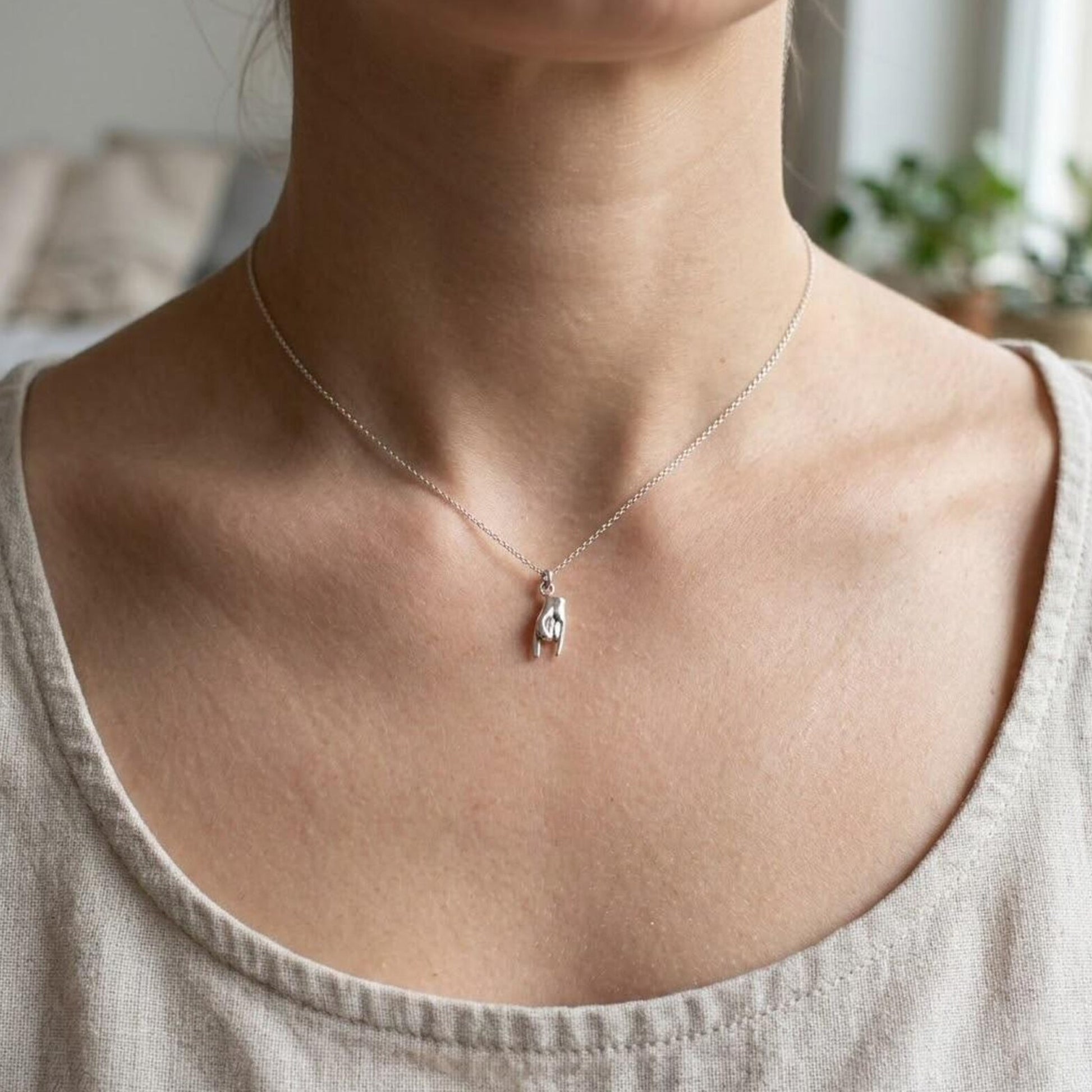 female model wearing silver italian mano hand necklace